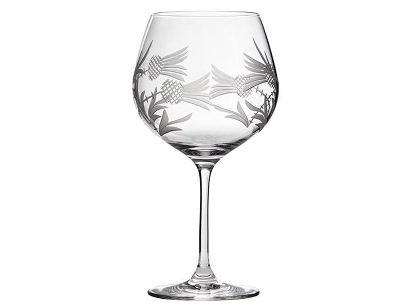 A single gin balloon or copa glass with a Scottish thistle design etched sideways around the exterior of the glass, giving a frosted motif.