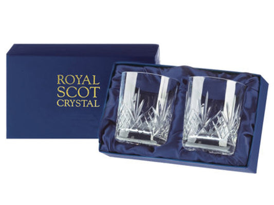 A pair of matching crystal tumblers with a highland cut that consists of a bed of diamonds with a five-pointed fan pointing up towards the smooth rim. They come in a navy blue silk-lined presentation box with gold branding on the lid.