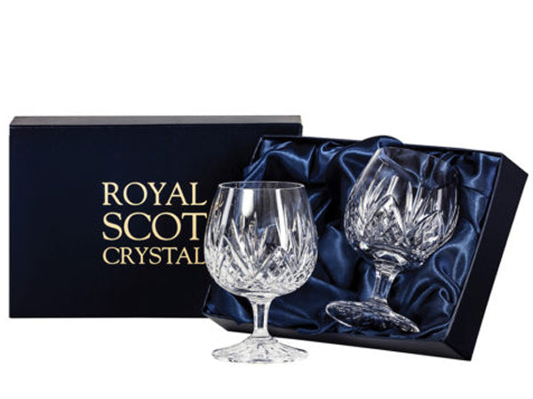 A pair of matching brandy glasses with a rounded bowl and slender stem, hand cut with a five-pointed fan design over a bed of diamonds