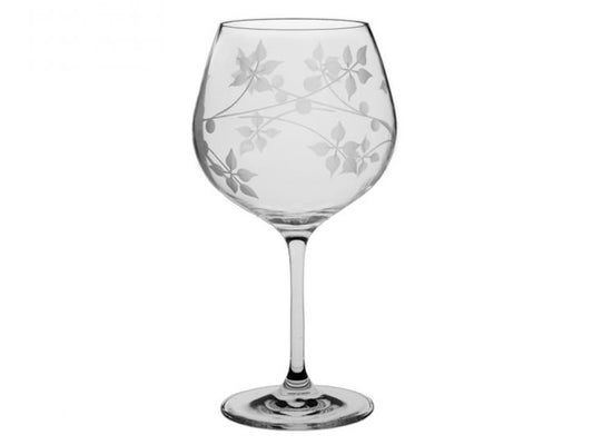 A large crystal gin copa glass with a delicate juniper plant design engraved into the exterior of the bowl, giving a frosted pattern effect
