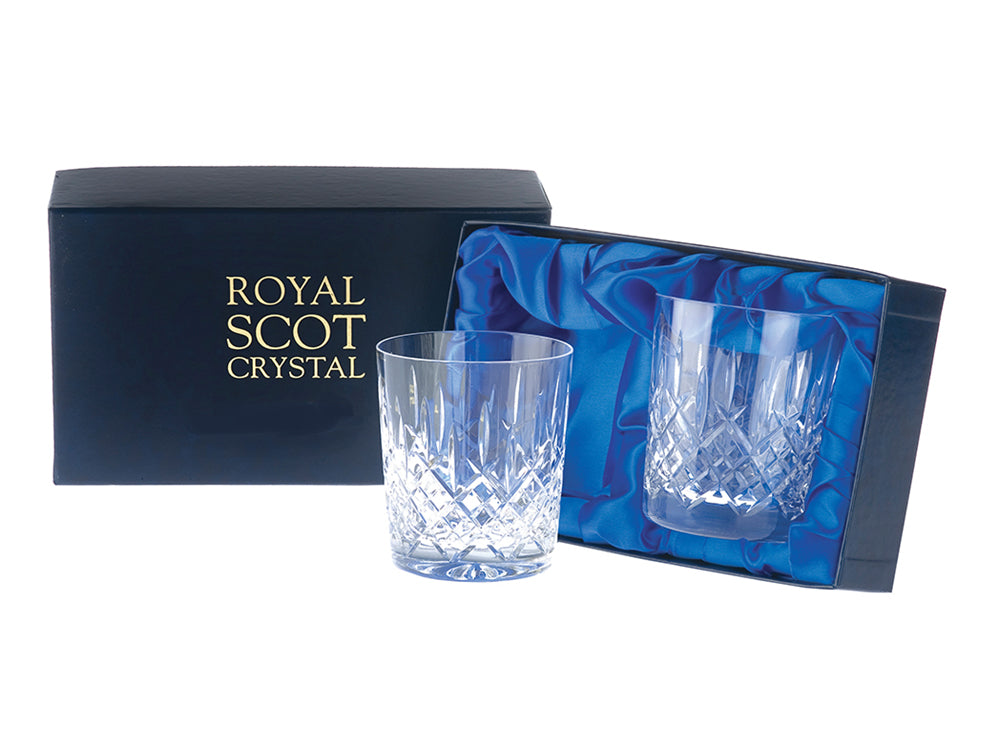 A pair of large square edged crystal tumblers, featuring a bed of diamonds and single dashes cut into the exterior, arriving in a navy blue silk-lined presentation box