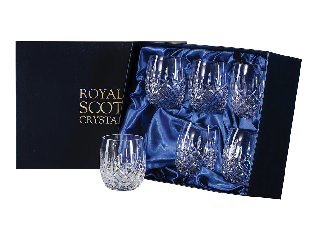 A set of six matching barrel shaped glasses with a cut pattern on the outside that consists of a bed of diamonds around the base, topped with single flicks going towards the smooth rim. They come in a navy-blue silk-lined presentation box with gold branding on the lid.