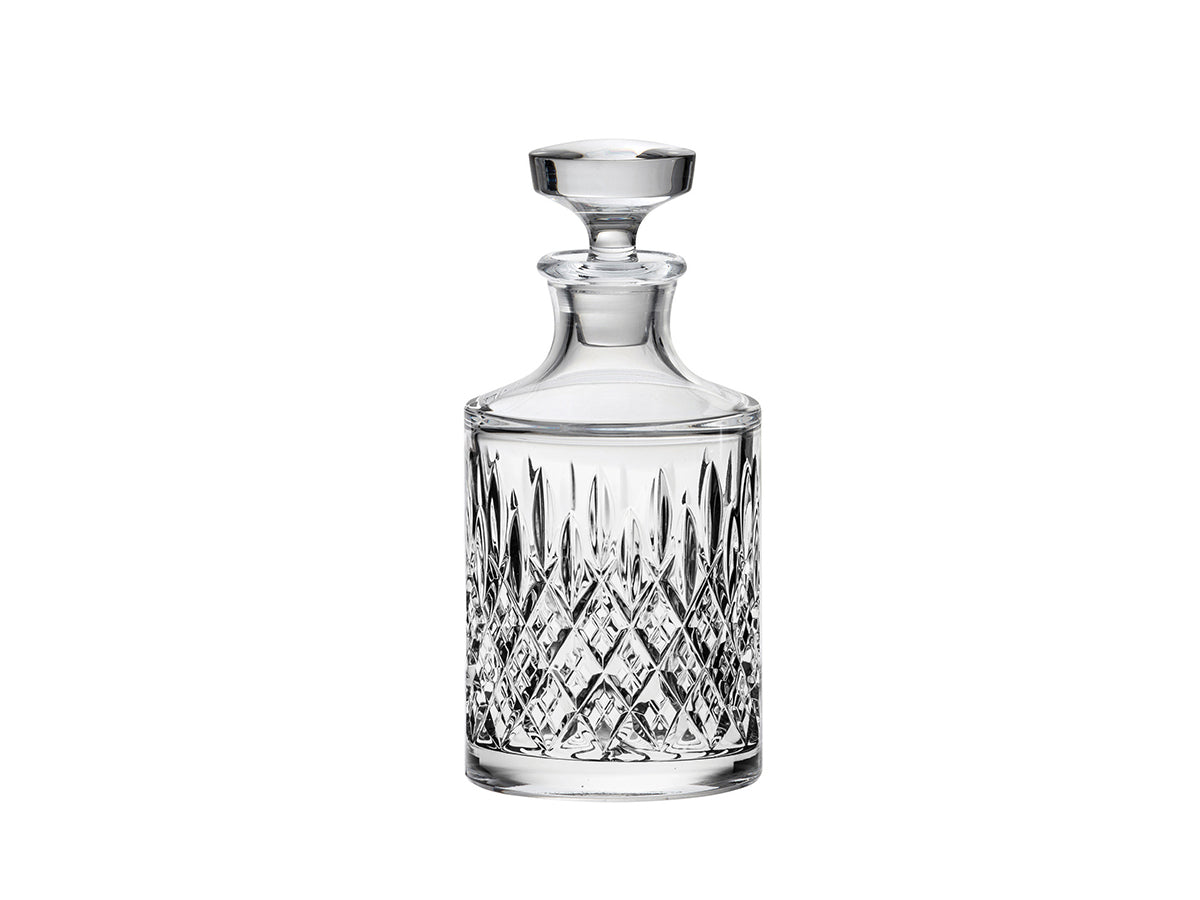 A crystal decanter with an intricate cut pattern made up of diamonds and dashes with a flat stopper