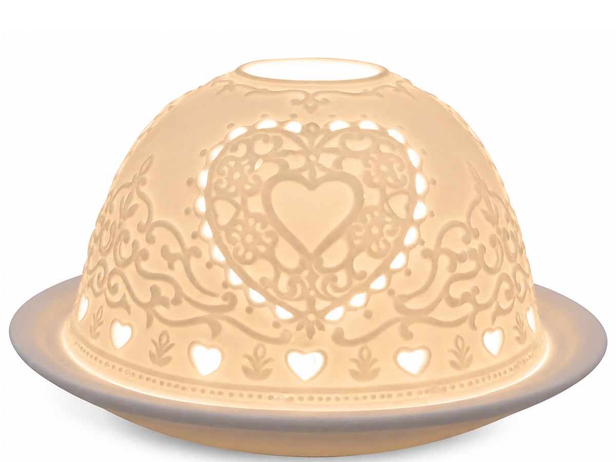 Light-Glow white unglazed porcelain dome tealight holder featuring an embossed lithophane design of a decorative heart pattern, glowing with warm ambient light from within.