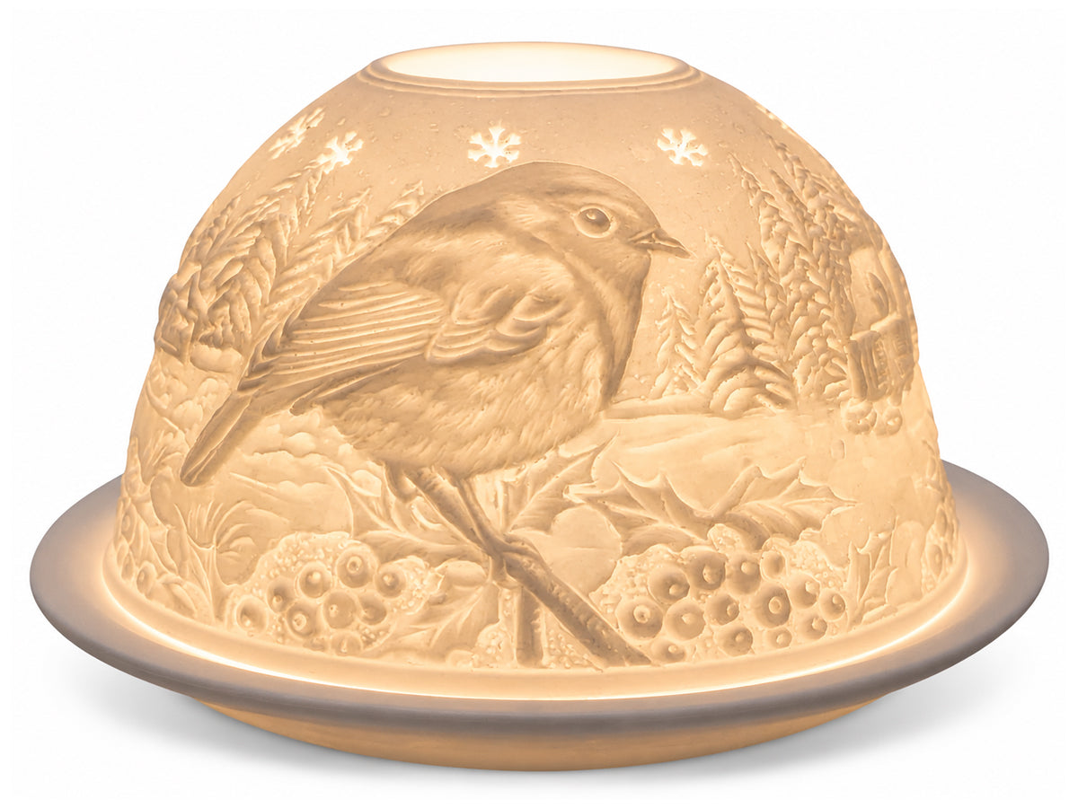 Light-Glow white unglazed porcelain dome tealight holder featuring an embossed lithophane design of a robin perched on winter holly branches, glowing warmly from within.
