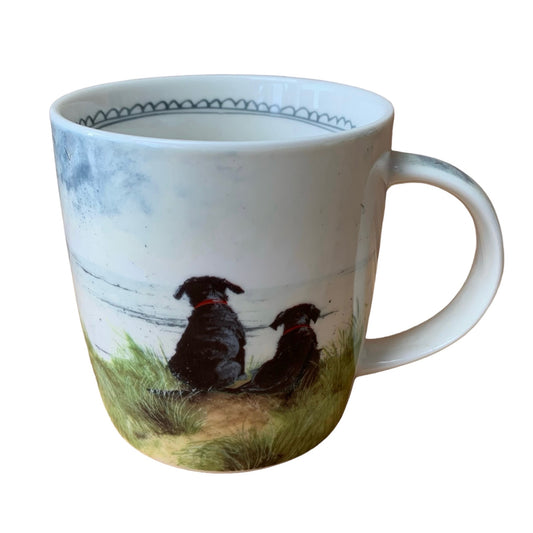 A mug by Alex Clark illustrated in watercolour of 2 dogs sitting on a grassy sanddune looking out to sea