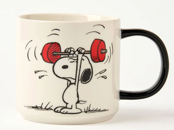 A white ceramic coffee mug featuring a black handle and a printed cartoon illustration of Snoopy lifting a red barbell, shown against a plain white background.