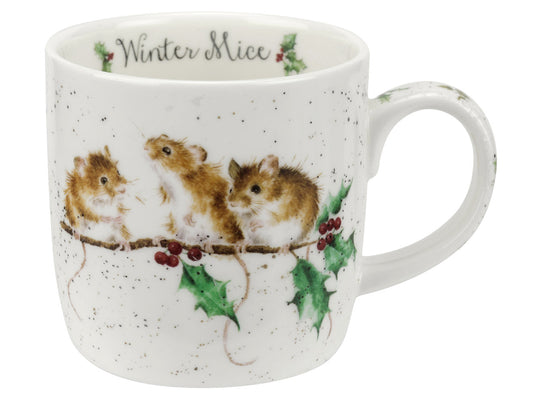 A white porcelain mug with three mice sitting on a holly branch on the front