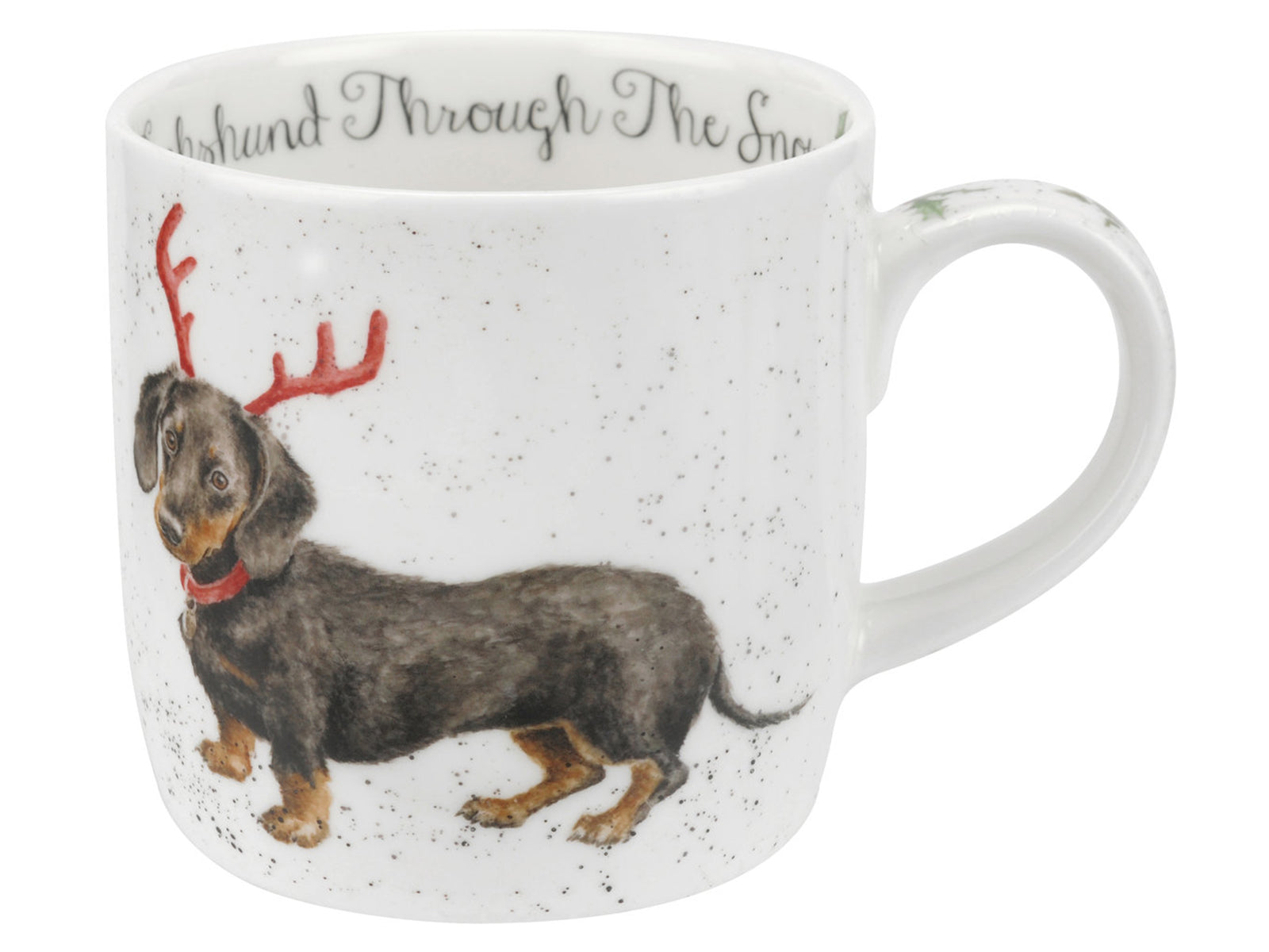 A white porcelain mug with a dachshund design on the front and the phrase 'dachshund through the snow' on the inside of the rim. The dog is wearing a red collar and red antlers