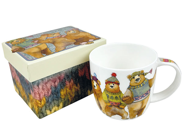 A white ceramic mug and its matching gift box, both decorated with a whimsical illustration of three bears wearing colorful knit sweaters and hats, set against a plain white background.
