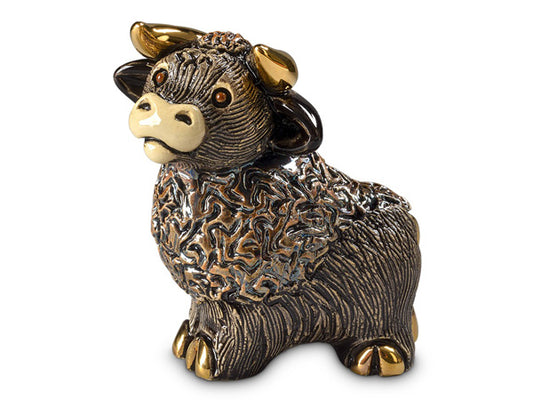 A miniature porcelain figurine of a bull in dark brown, finished with an shimmering silvery glaze and golden details on the hooves and horns.