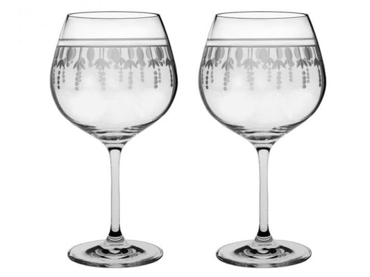 A pair of crystal gin balloons with an opulent design around the rim, with small dashes going towards the bottom.
