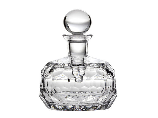 A round crystal perfume bottle with an art-deco style design cut into the exterior. It has a spherical stopper with a slender dabber inside.