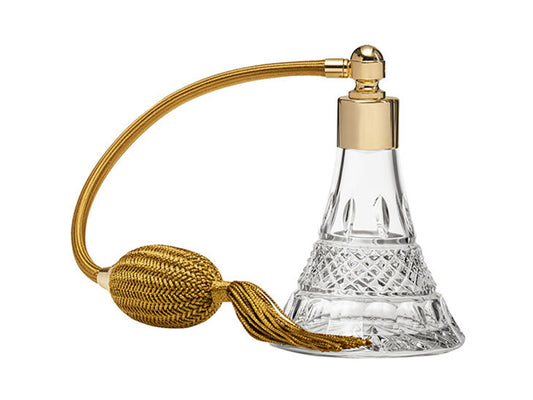 A crystal perfume atomiser with a clear bottle, cut with an intricate regency design, with a gold top and puffer