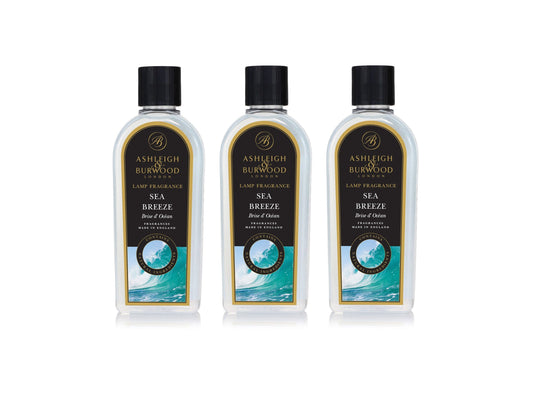 Three bottles of sea breeze lamp fragrance with clear bottles, black caps and labels with blue details