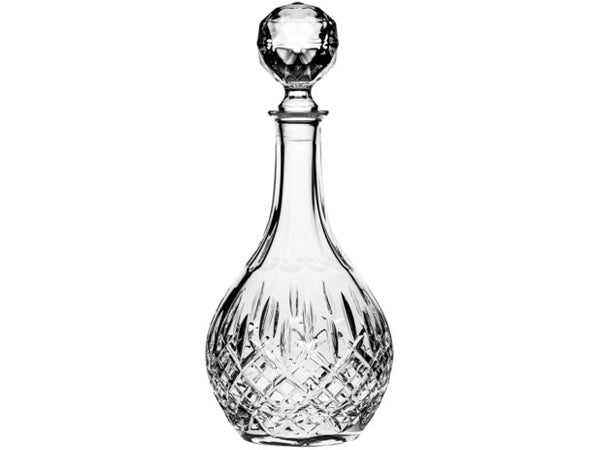 A long-stemmed crystal decanter with a round stopper, cut around the outside
