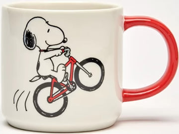 This Magpie Peanuts Snoopy mug showcases a whimsical illustration of Snoopy riding on a vibrant red bike. The reverse side displays bold black lettering that proudly proclaims 'Born to Ride'.