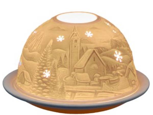 A dome-shaped decorative lamp or cover with an embossed winter village scene, shown illuminated against a plain white background.