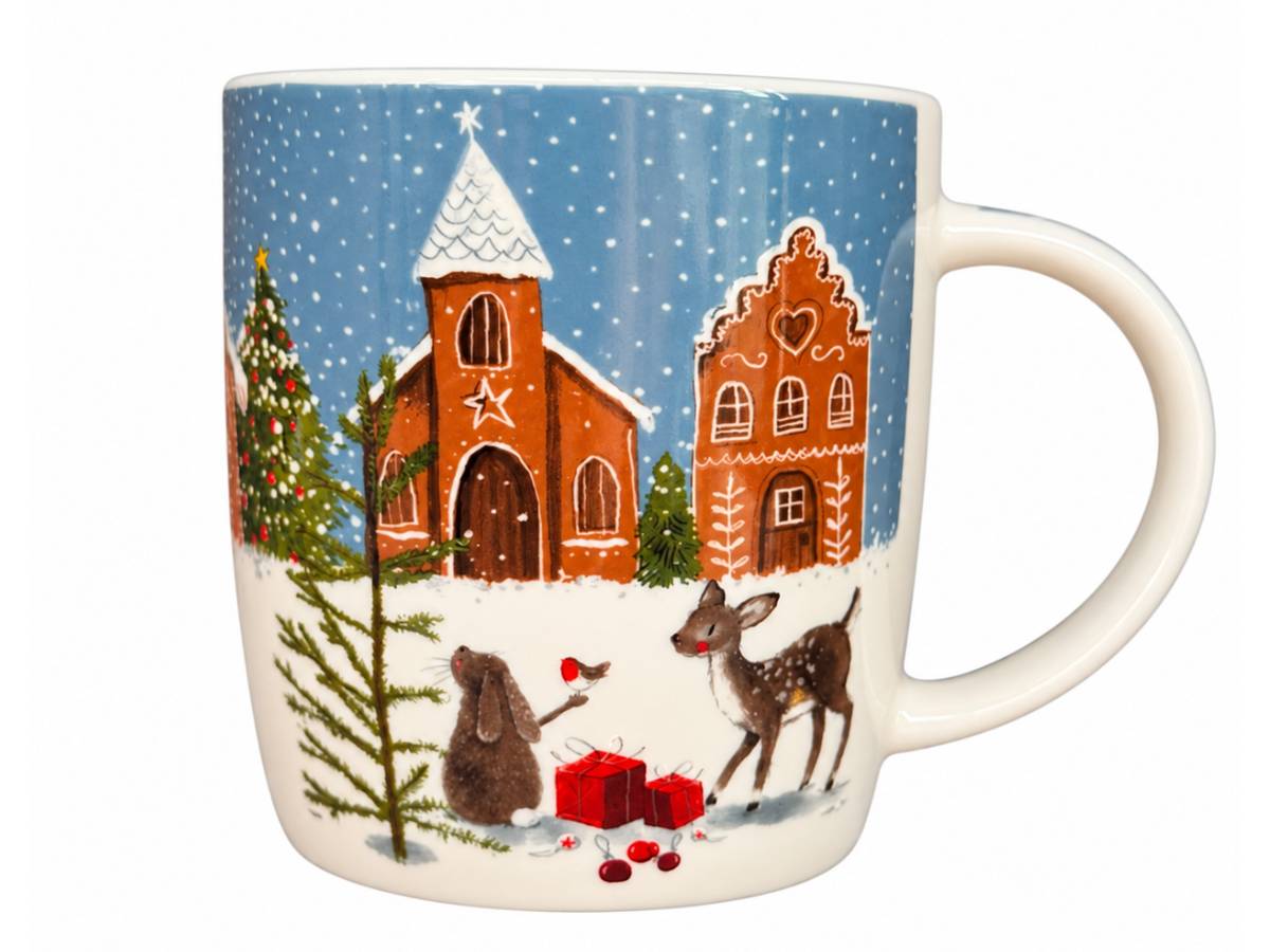 A white ceramic mug featuring a festive Christmas village illustration with snow, a church, a gingerbread house, trees, and animals on a blue sky background.