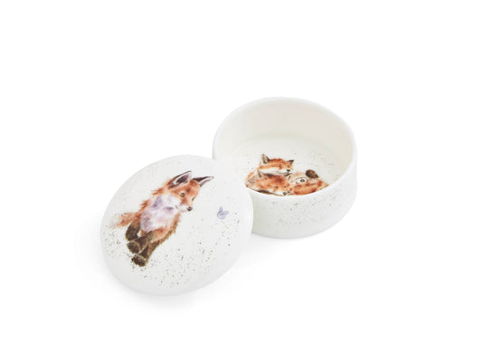 A white china lidded box with a fox design on the lid and inside the box. It is round.