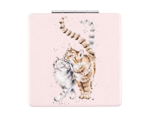 The front of this pale pink pocket mirror depicts two cats, one grey and one brown, with their tails intertwined.