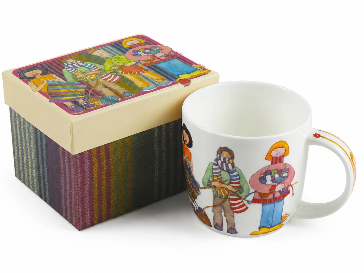 A white ceramic mug with colorful illustrated characters and a matching decorative gift box with a striped multicolor base and a cream lid, shown on a white background.