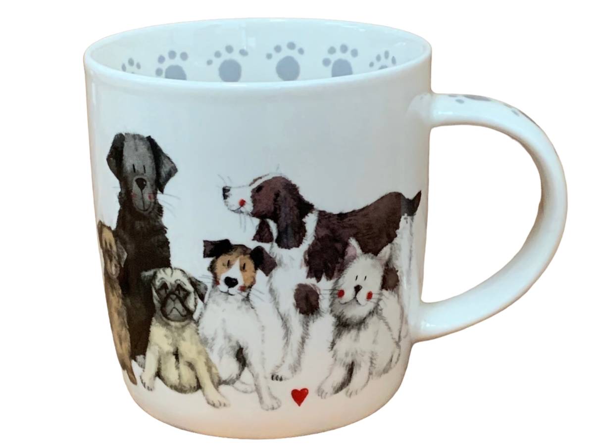 A white ceramic mug featuring a detailed illustration of various dog breeds on the front, with a small red heart at the bottom and gray paw prints printed inside the rim.