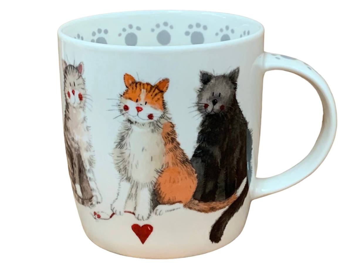 A white ceramic mug featuring an illustration of three cute cats sitting together, with a small red heart at the bottom and gray paw prints along the inner rim.