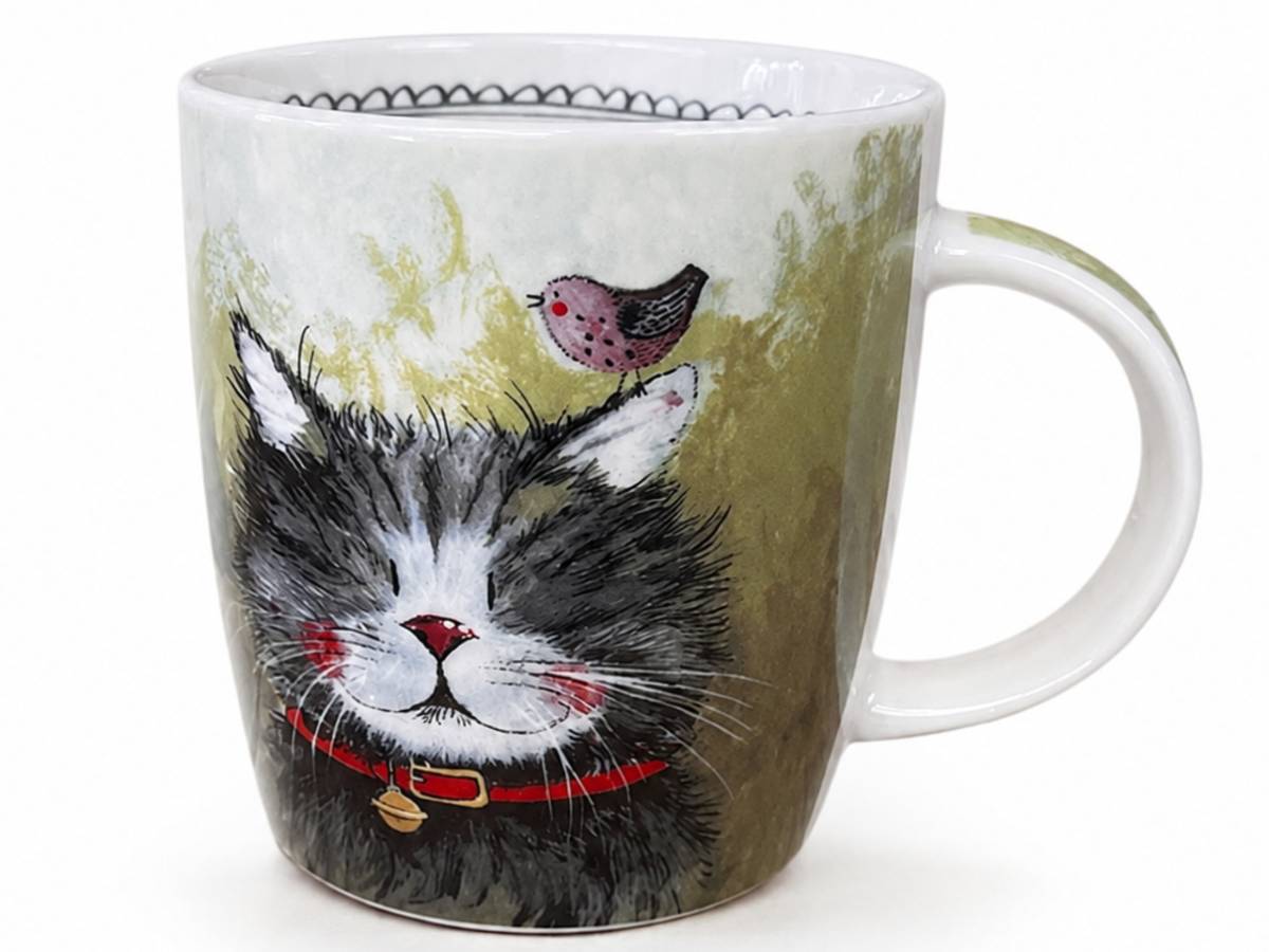 A white ceramic mug featuring a whimsical illustration of a black and white cat wearing a red collar with a gold bell, with a small pink bird perched on its head against a textured olive-green background.