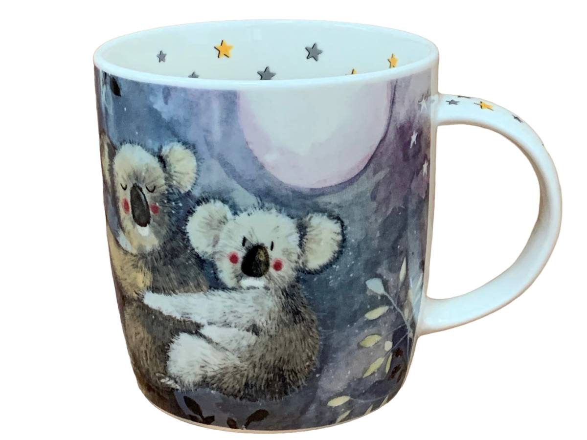 A white ceramic mug featuring a watercolor-style illustration of two koalas under a full moon, with small stars and leaves on the printed design and handle.