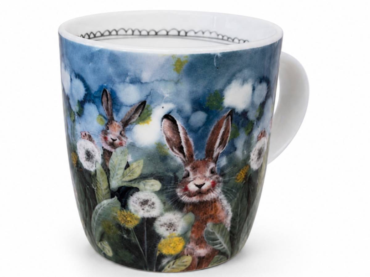 A white ceramic mug featuring a detailed watercolor-style illustration of two brown hares among white dandelions and green leaves against a blue sky background.