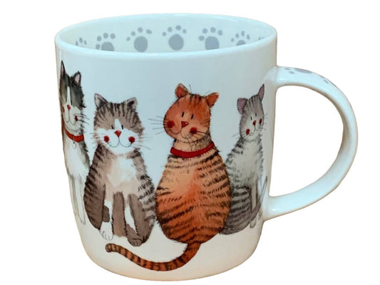 A white ceramic mug featuring a colorful illustration of four cats sitting together, with gray paw prints printed inside the rim.