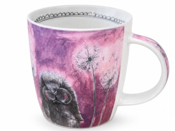 A white ceramic mug featuring a whimsical illustration of a fluffy black cat with pink eyes among dandelions against a purple and pink watercolor background.
