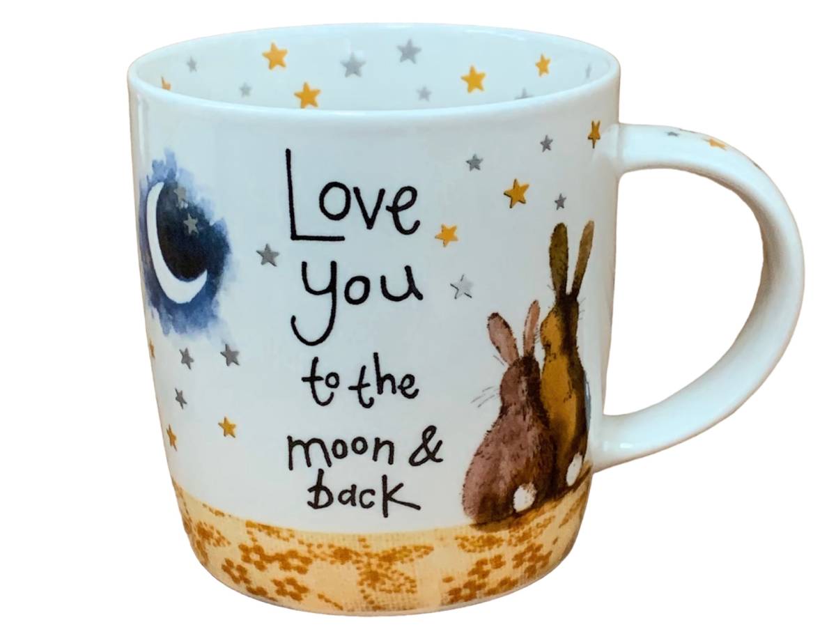 A white ceramic mug featuring a whimsical design with the text 'Love you to the moon & back', a blue crescent moon, small stars, and a brown rabbit illustration near a gold speckled base.