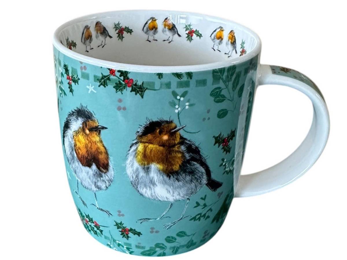 A ceramic mug featuring a turquoise background decorated with two robin birds, holly leaves, and small white birds along the inner rim, shown on a plain white background.