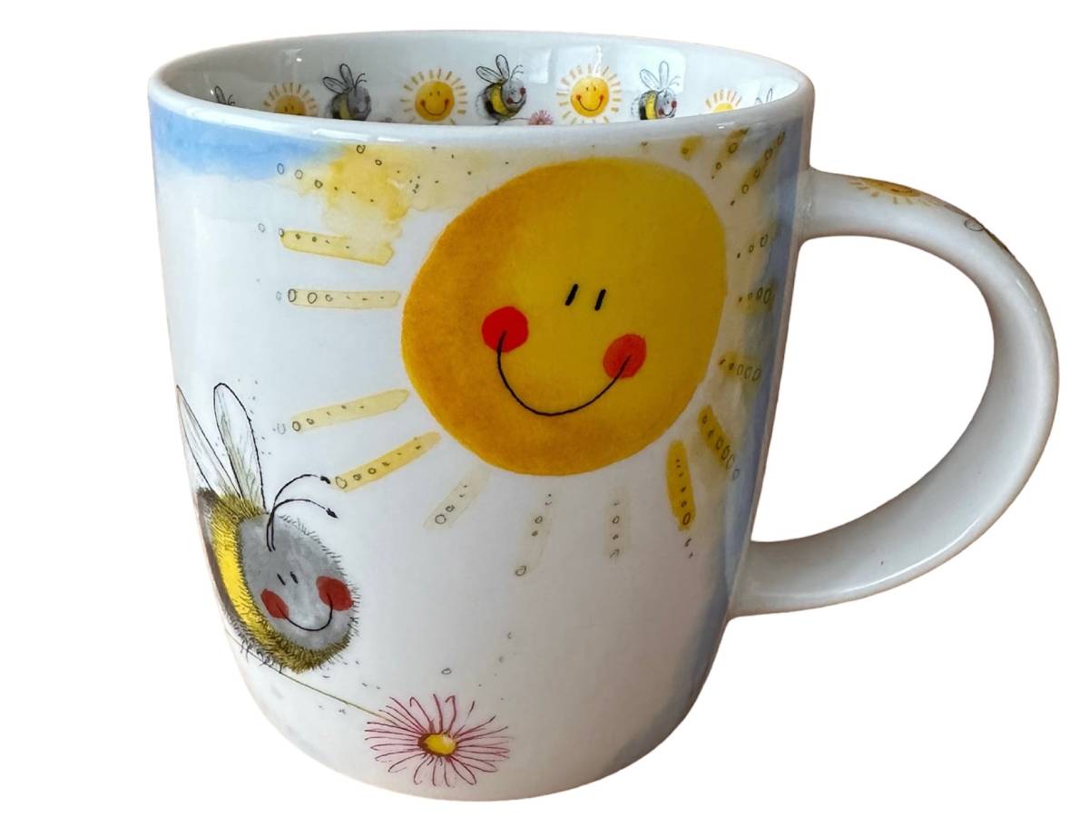 A white ceramic mug decorated with a cheerful yellow smiling sun, a friendly bee, and small daisy flowers, shown against a plain white background.
