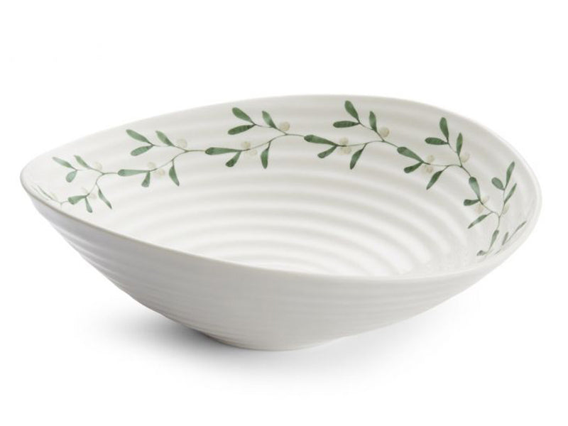 A large serving bowl that has been made from a white porcelain finished with a clear glaze. Part of Sophie Conran's Mistletoe range, the piece has been textured with a ripple effect and printed with a chain of mistletoe leaves around the inner rim of the bowl. It is perfect for serving up some mixed vegetables or a heap of roast potatoes for your Christmas dinner.