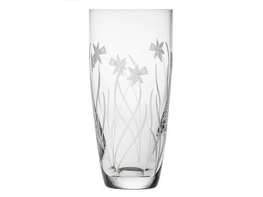 A tall crystal vase with a daffodil motif carved into the sides