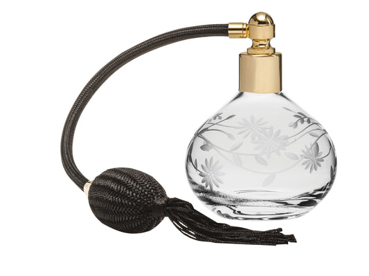 A crystal atomiser with a delicate daisy design engraved into the bottle, with gold hardware and a sleek black puffer