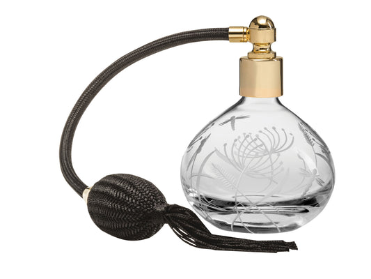 A crystal perfume atomiser with dragonflies and delicate botanicals engraved into the exterior, fitted with gold hardware and a black puffer