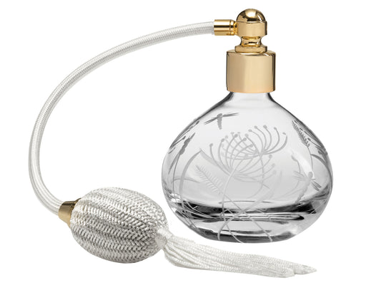 A crystal perfume atomiser with a cream puffer. The glass bottle has delicate dragonflies and botanicals cut into the sides, giving a frosted effect