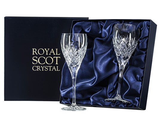 A pair of large wine glasses in a navy blue presentation box with gold branding on the lid. The glasses are cut with a bed of diamonds on the bowl, with a triple-flicked fan sitting above it.