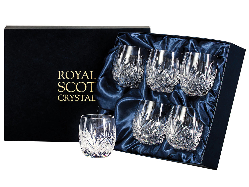 A set of six matching barrel shaped tumblers with Royal Scot's highland design, which has a bed of diamonds around the base, topped with a deep five-pointed fan. They have smooth rims and come in a navy-blue silk-lined presentation box with gold branding on the lid.