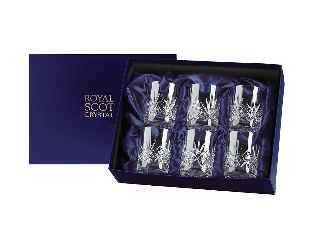 A set of six whisky glasses with a bed of diamonds cut around the base with a five-pointed fan above it and a smooth rim. They come in a navy-blue silk-lined presentation box with gold branding on the lid.
