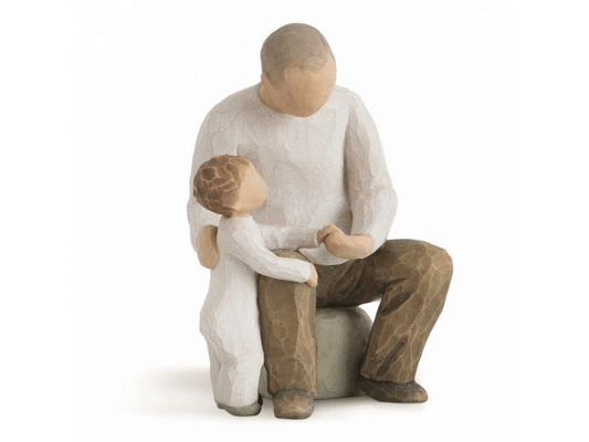 This Willow Tree figurine titled 'Grandfather', shows off a sweet duo sharing a familial moment together. A faceless elderly man is sitting on a stool with a young child holding onto his knee and the grandfather's hand. This figurine captures the essence of love, warmth, and family bonding, making it a timeless and meaningful gift or decoration for any home.