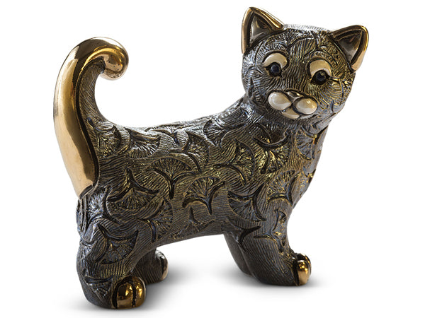 A handcrafted ceramic cat figurine with gold-painted ears, tail, and toes. Handpainted and finished with platinum enamel for an iridescent sheen. Intricate fan-shaped motifs patterned into its fur. Contrasting white eyebrows and mouthpieces stand out against its silver fur and striking blue eyes.