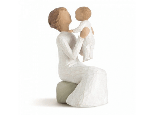 Willow Tree's 'Grandmother' figurine showcases a heartwarming moment between a faceless grandmother and her young faceless grandchild, as the grandmother holds the child up in the air. The figurine captures the essence of the special bond shared between a grandparent and grandchild.