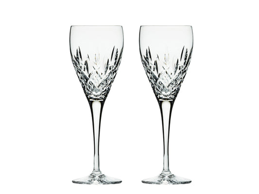 A pair of stemmed port glasses with a bed of diamonds cut around the base of the bowl, with single flicks going up towards the smooth rim. They come in a navy-blue silk-lined presentation box with gold branding on the lid.