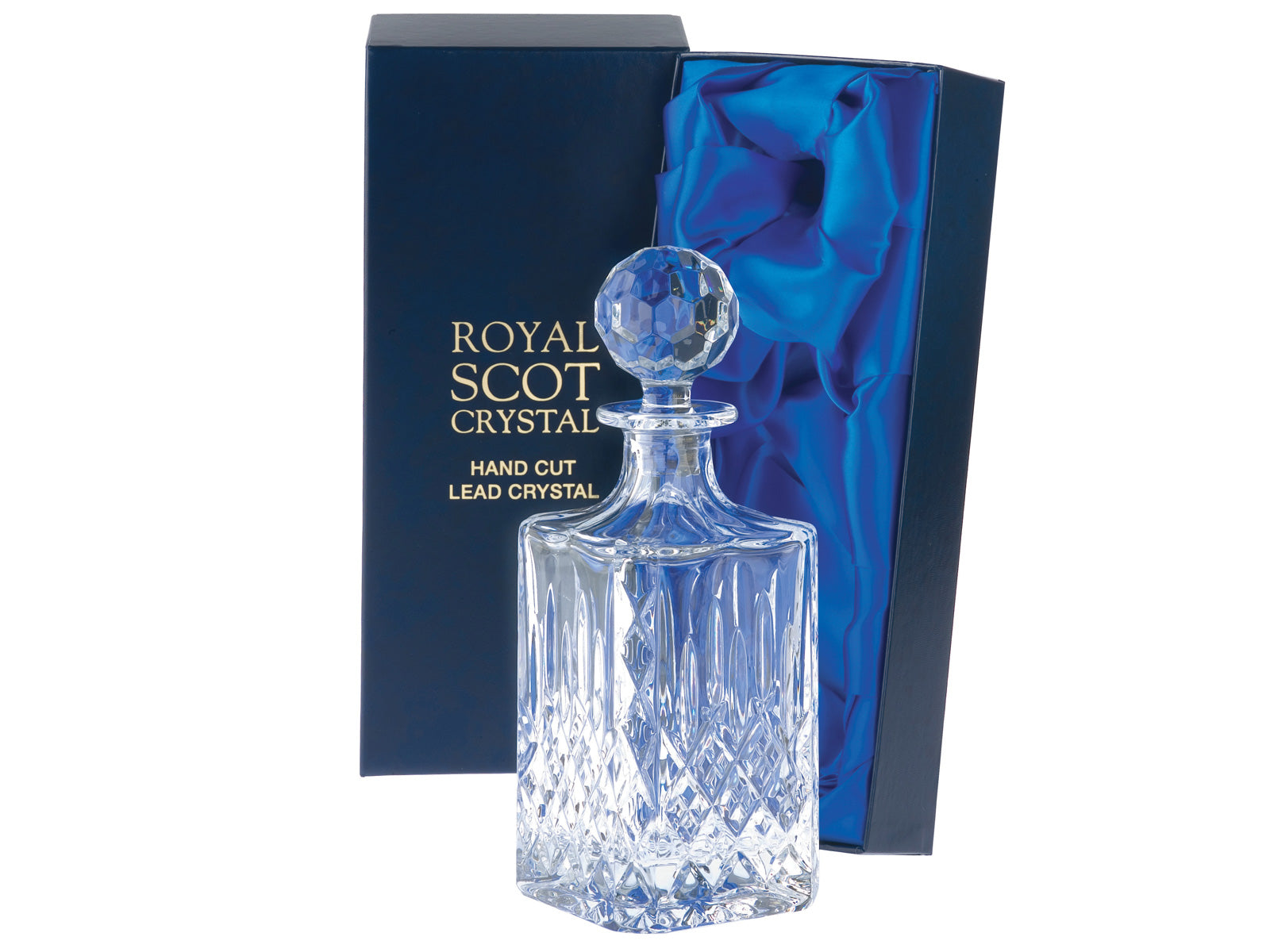 A square crystal spirit decanter with a bed of diamonds cut into the exterior, topped by single flicks up towards the top. It is stopped by a golf-ball shaped stopper. It comes in a navy blue silk-lined presentation box.