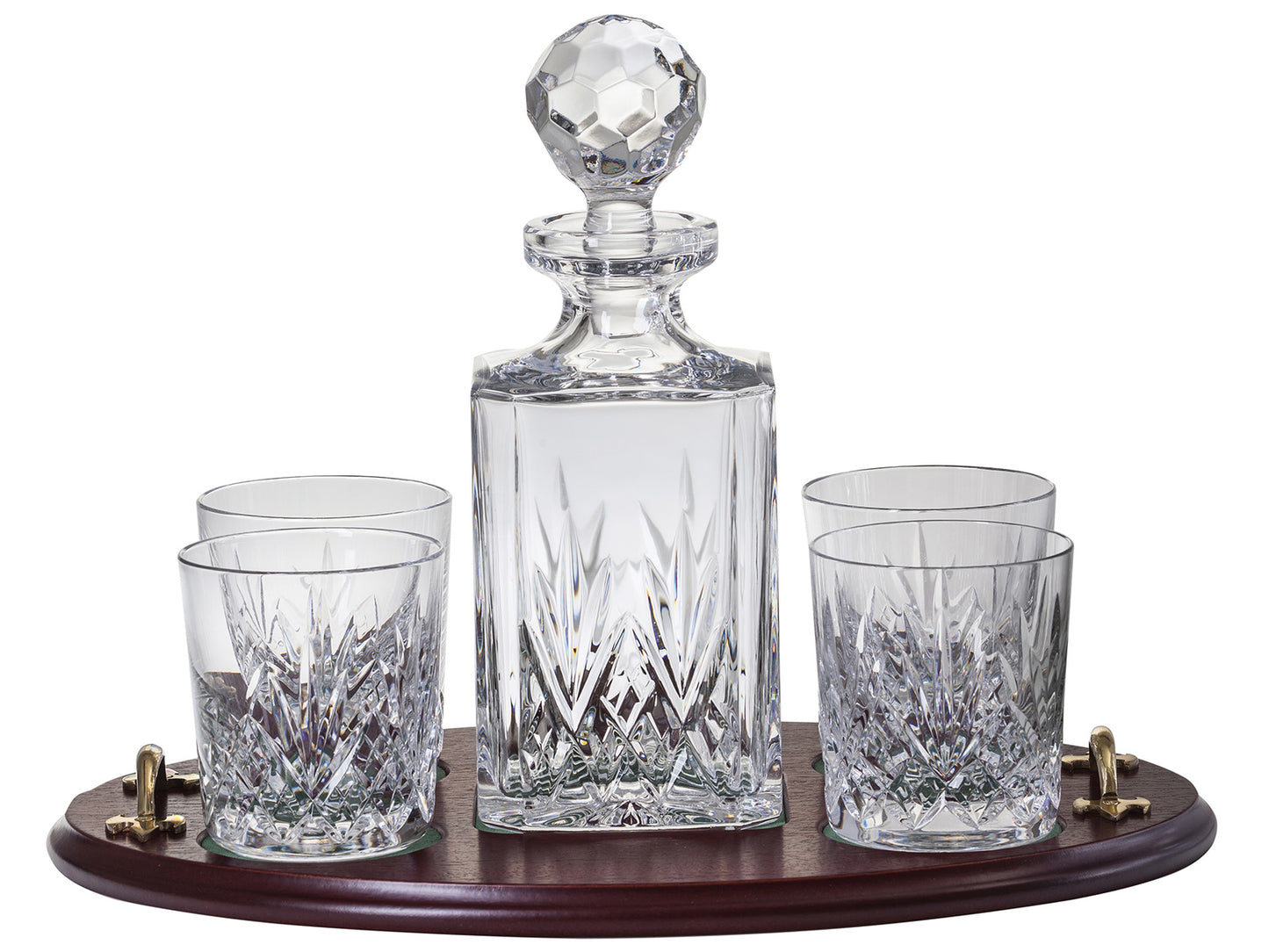 A crystal decanter and four matching whisky glasses with an intricate cut pattern on the outside, all on a wooden serving tray with gold handles